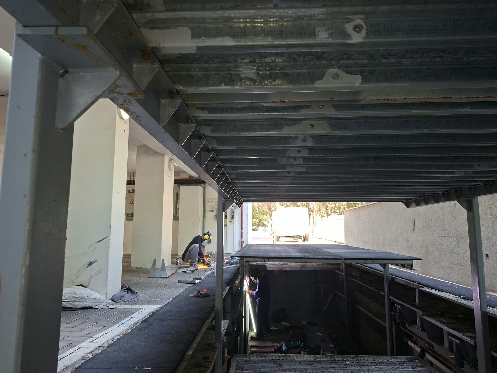 מבט אל מתקן חניה שקוע מתחת למשטח מתכת מוגבה